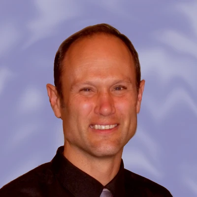 A headshot photo for Dr. Ron Engler smiling at the camera